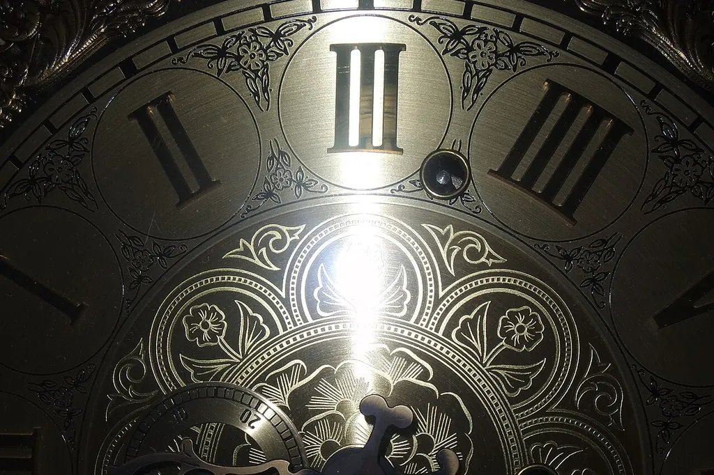 Le cadran d'une horloge ancienne à chiffres romains, faiblement éclairé dans l'obscurité
